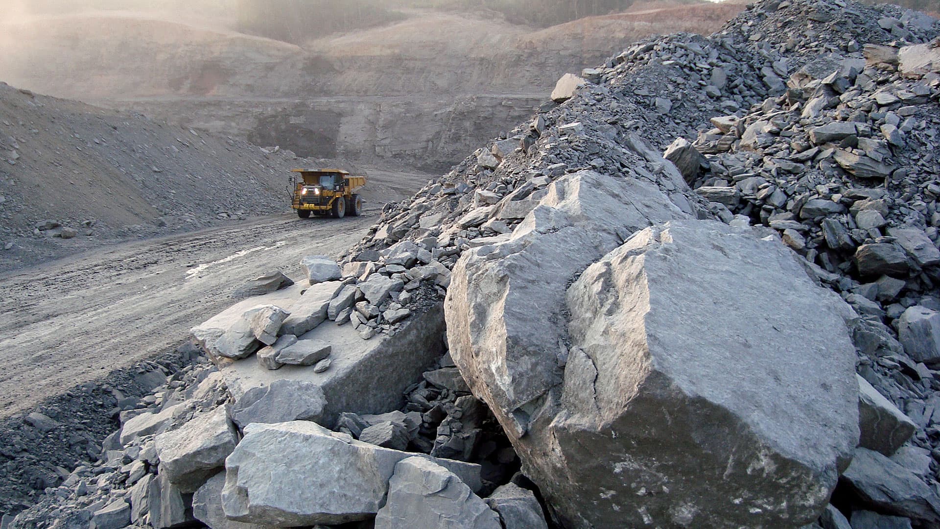 Off Highway Truck on Haul Road with Rocks in foreground